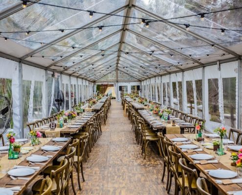 Clear Tent Rental With Bistro Lighting, Wooden Strata Flooring, Farm Tables & X Back Chairs