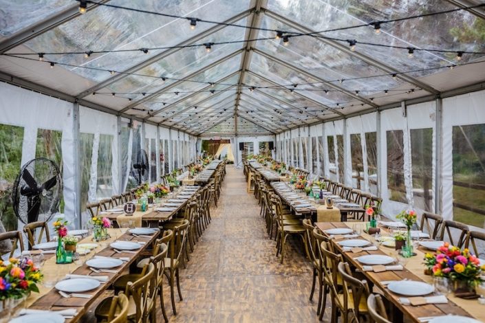 Clear Tent Rental With Bistro Lighting, Wooden Strata Flooring, Farm Tables & X Back Chairs