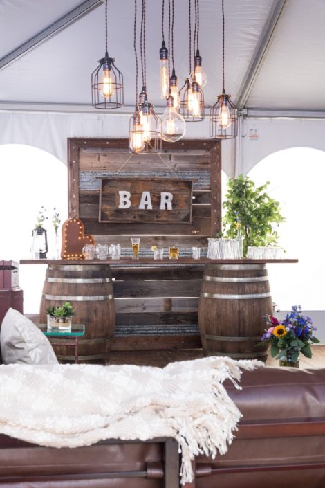 Whiskey Barrel Bar, Barnwood Decor Wall, Edison Bulb Chandelier & Pecan Lounge Furniture - Rustic Wedding Decor Rentals