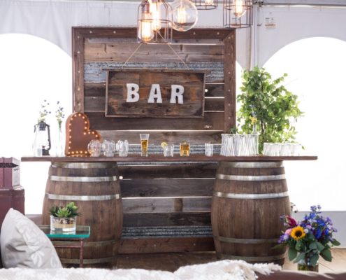Whiskey Barrel Bar, Barnwood Decor Wall, Edison Bulb Chandelier & Pecan Lounge Furniture - Rustic Wedding Decor Rentals