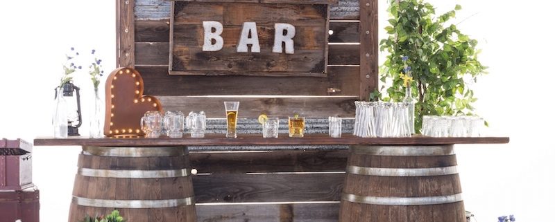 Whiskey Barrel Bar, Barnwood Decor Wall, Edison Bulb Chandelier & Pecan Lounge Furniture - Rustic Wedding Decor Rentals
