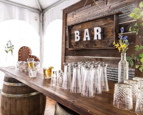Rustic wedding ideas - Rustic Whiskey Barrel bar rental for wedding, Pilsner Glasses & Barnwood Decor Wall With Bar Sign