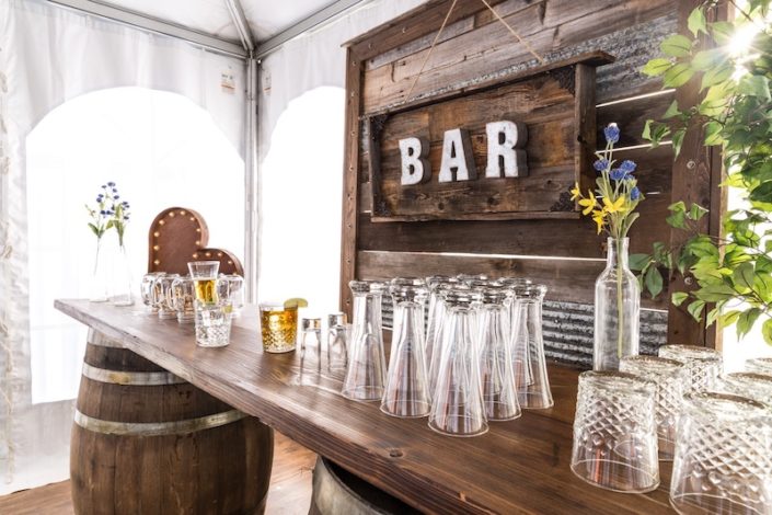 Rustic wedding ideas - Rustic Whiskey Barrel bar rental for wedding, Pilsner Glasses & Barnwood Decor Wall With Bar Sign