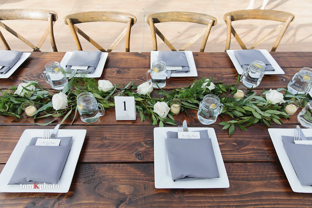 Rustic Farm Table setting with x back chairs and grey napkins