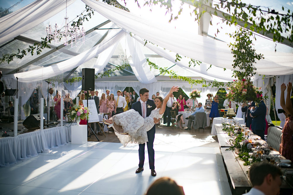 Larkspur Vail bride and groom inside clear wedding tent with draping